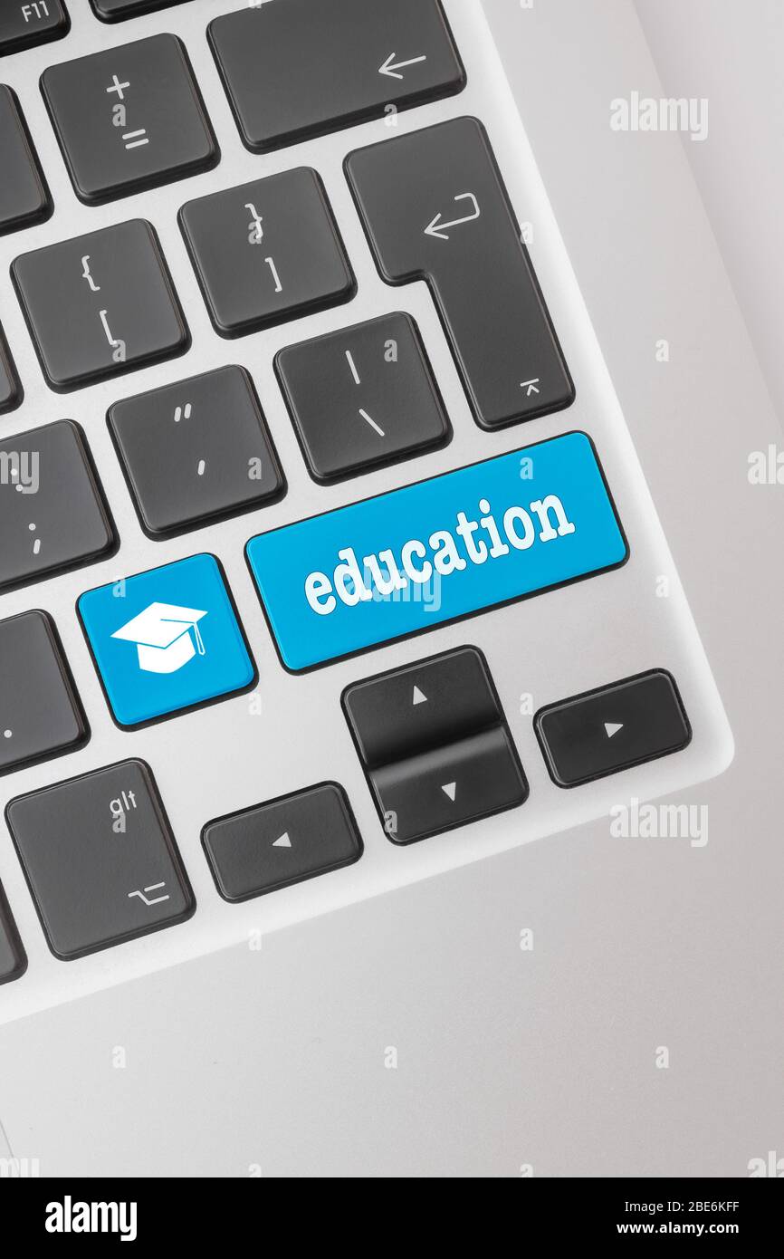 Concepto de escolarización en casa. Teclado de ordenador con un sombrero de graduación y la palabra educación. Foto de stock