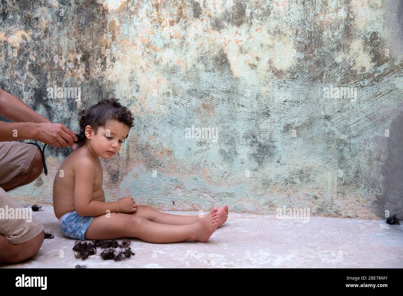 Thiago tiene la cabeza afeitada por su padre en su vigésimo primer día de auto-aislamiento debido a la pandemia de Covid-19 en un hogar temporal en Mérida, Yucatán, México el 4 de abril de 2020. El fotógrafo Benedicte Desrus dijo: "Toda la familia decidió afeitarse la cabeza, ya que entendemos que esta cuarentena podría durar varios meses y el tiempo es ahora de 42 grados Celsius aquí. Además, es una manera de recordar lo que vivimos en el futuro." Thiago, de 3 años, es hijo del fotógrafo. Fue documentado como parte de un proyecto titulado “cuando crecí” sobre un niño que crecía en cuarentena, lejos de otros Foto de stock