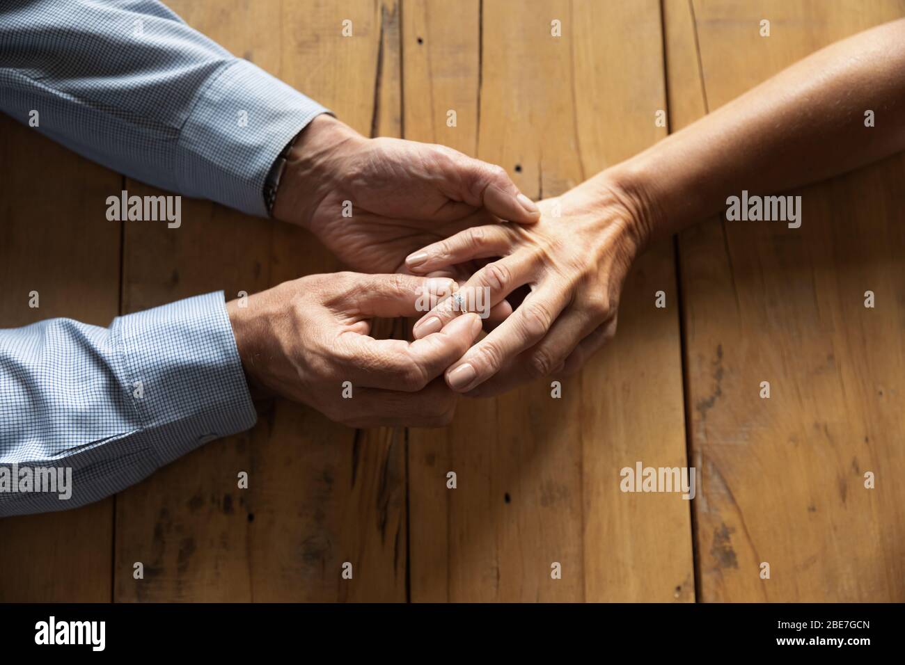 Hombre mayor poniendo anillo de compromiso en la mujer dedo cerca de arriba Foto de stock