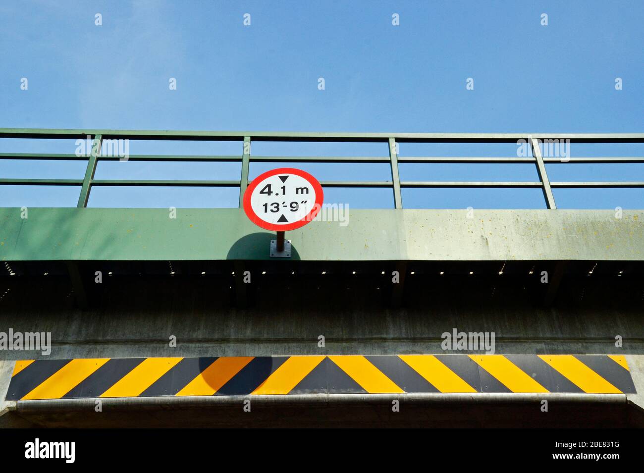 4.1m, 13' 9' señal de altura del puente, con franja de advertencia negra y amarilla en el túnel rural Foto de stock
