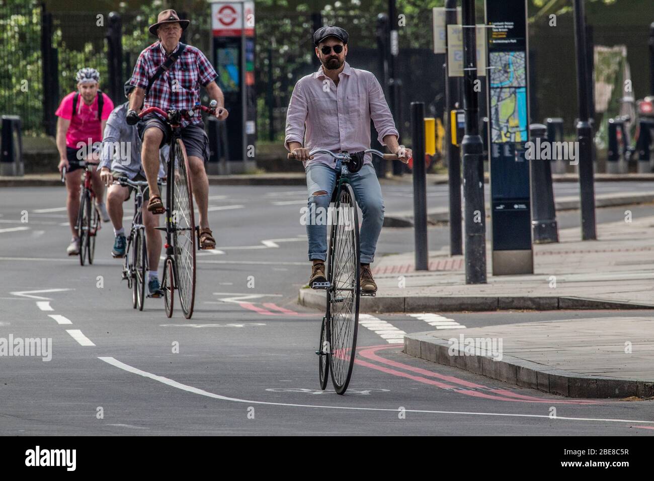 Los ciclistas de Penny-Farthings se llevan a las tranquilas carreteras durante las vacaciones de Semana Santa durante el cierre de coronavirus en la capital, Londres, Reino Unido Foto de stock