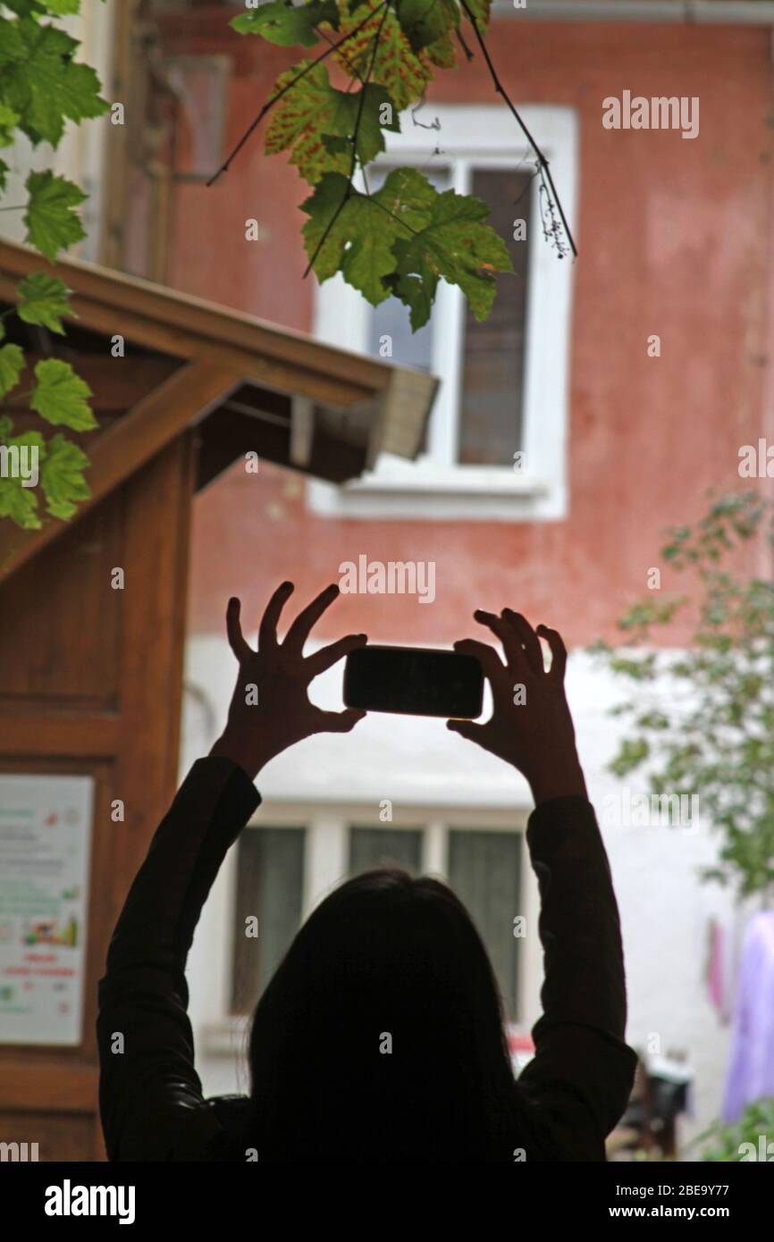 Persona joven tomando una foto usando un celular. Turista visitando Brasov, Rumania. Foto de stock