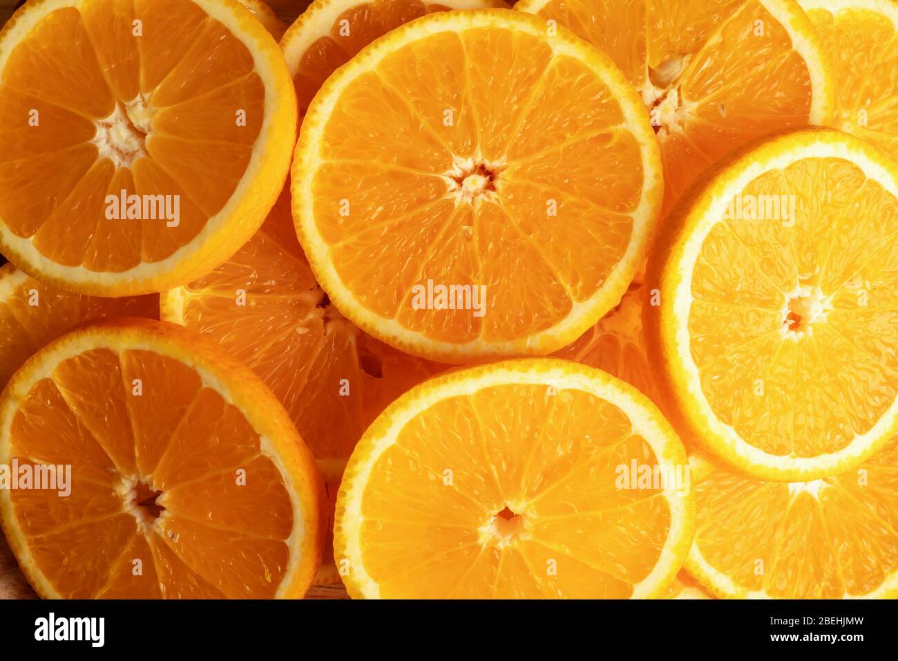 Fondos de vista superior y textura de frutas de naranja cortadas en pedazos. El resultado es agrio o dulce. Contiene calcio, potasio, vitamina A y C. Foto de stock