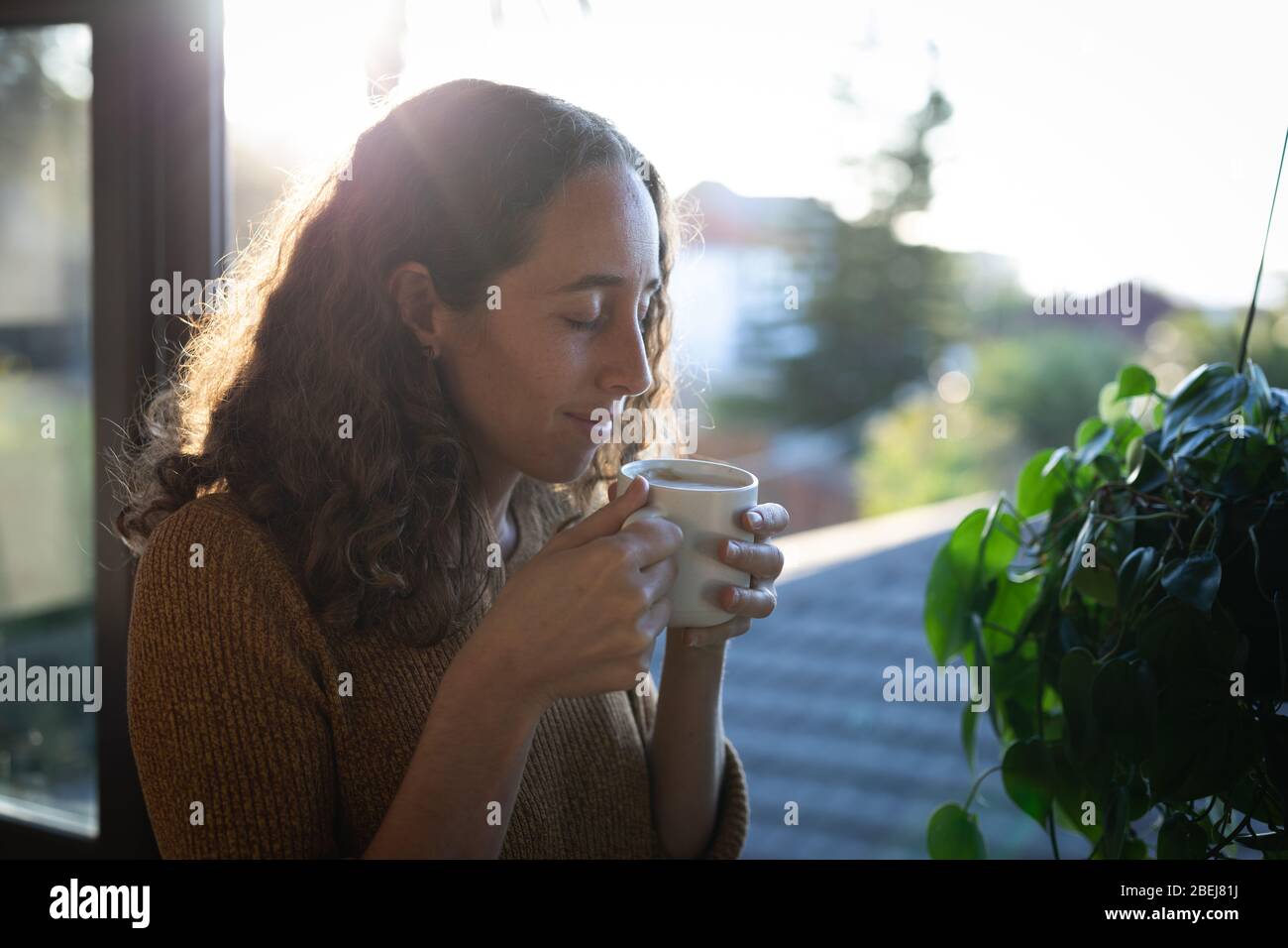 Mujer tomando café. Distanciamiento social en bloqueo de cuarentena durante la epidemia de coronavirus. Foto de stock