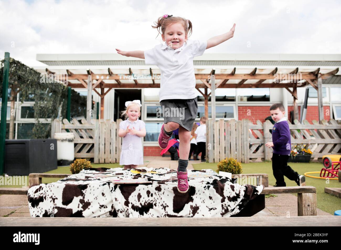 Niños en el área de juegos al aire libre en una escuela de párvulos en Darlington, County Durham, Reino Unido. 18/4/2018. Fotografía: Stuart Boulton. Foto de stock