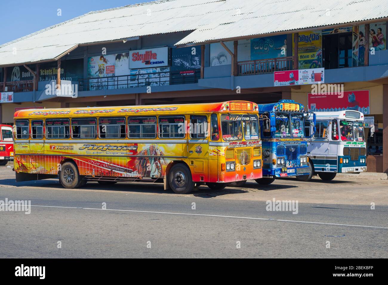 MATARA, SRI LANKA - 17 DE FEBRERO de 2020: Tres autobuses multicolores 'Ashok Leyland' contra el fondo de la estación de autobuses de la ciudad Foto de stock