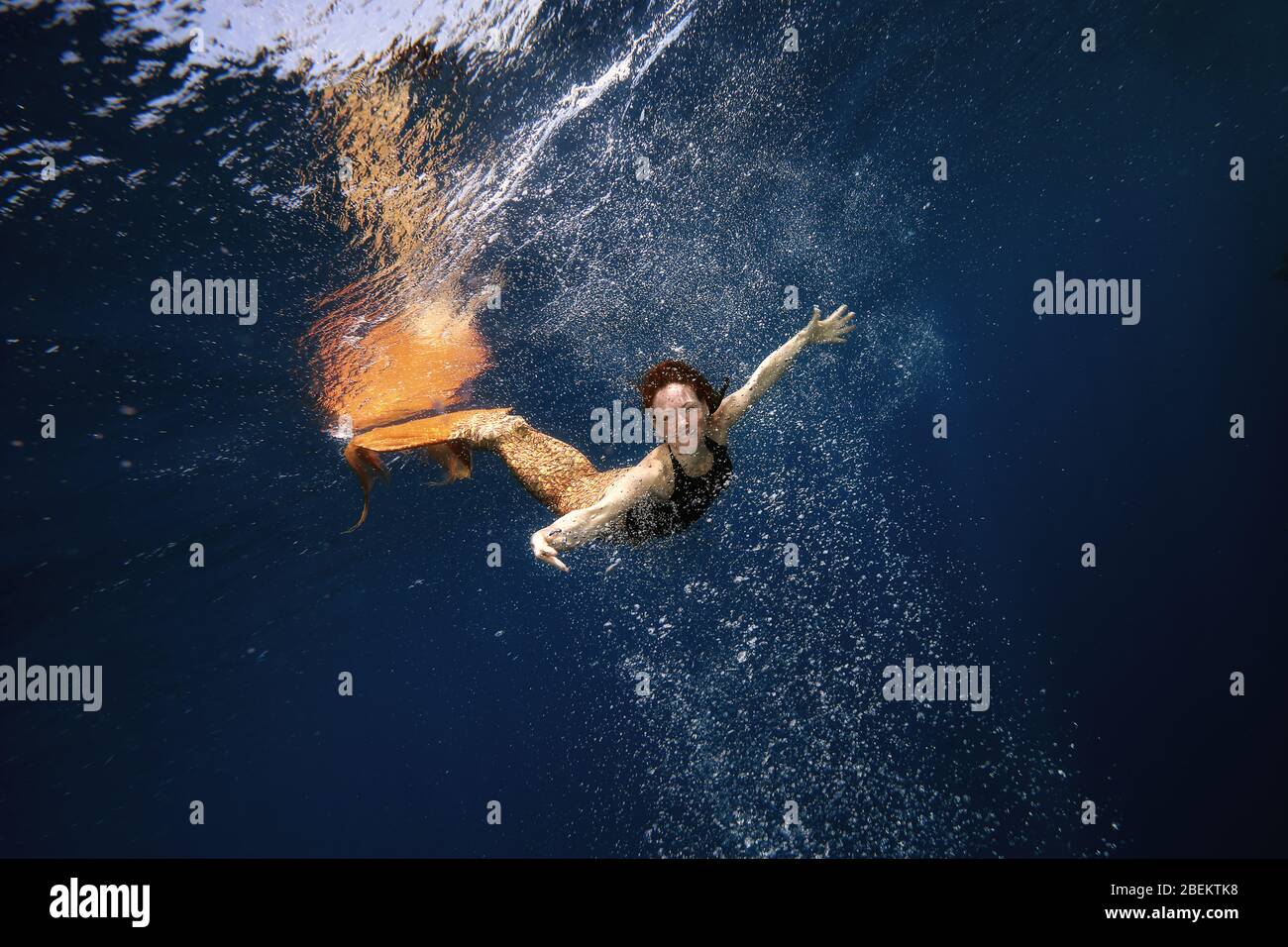 Mermaid nadando bajo el agua en el océano Foto de stock