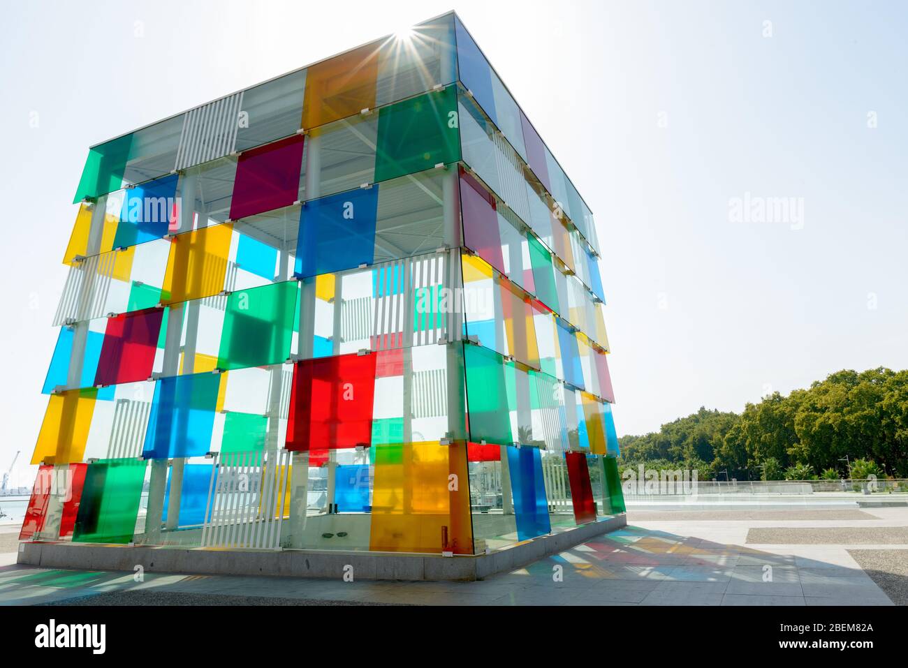 Edificio de vidrio con forma cuadrada y flare de lente, con arquitectura artística abstracta colorida Foto de stock