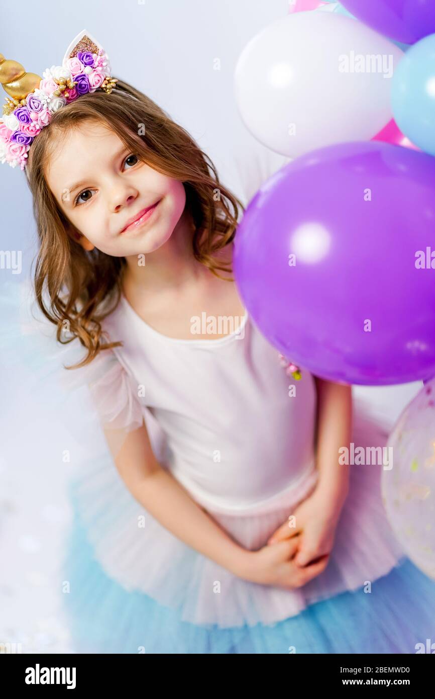 un pequeño niña con un unicornio aro en su cabeza en contra un antecedentes  de verde foto decoración. cumpleaños para niños. S t. Patricio es día  celebracion 30413033 Foto de stock en