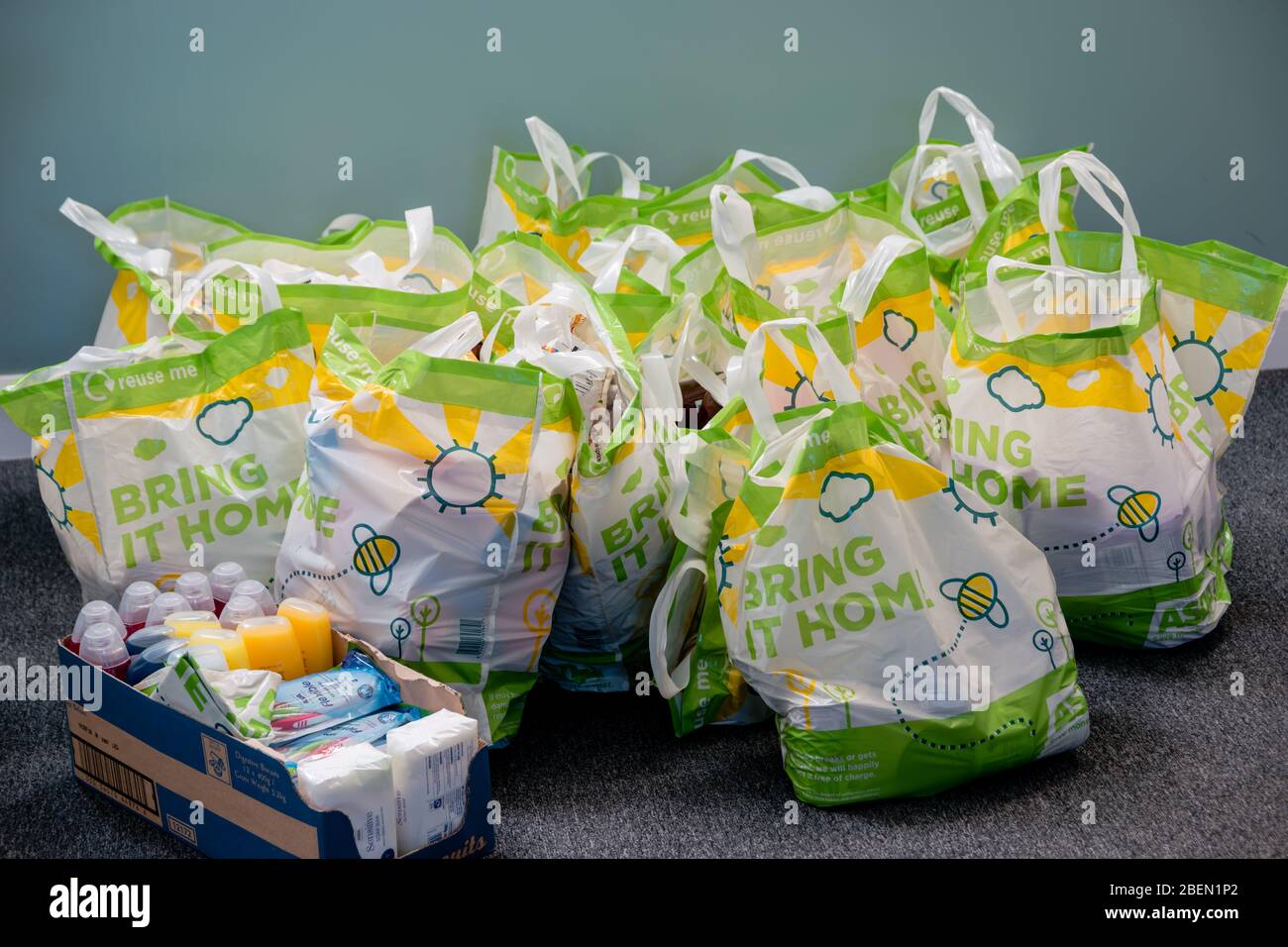 Donaciones en un banco local de alimentos de la iglesia de Trussell Trust en bolsas de transporte y una caja Foto de stock