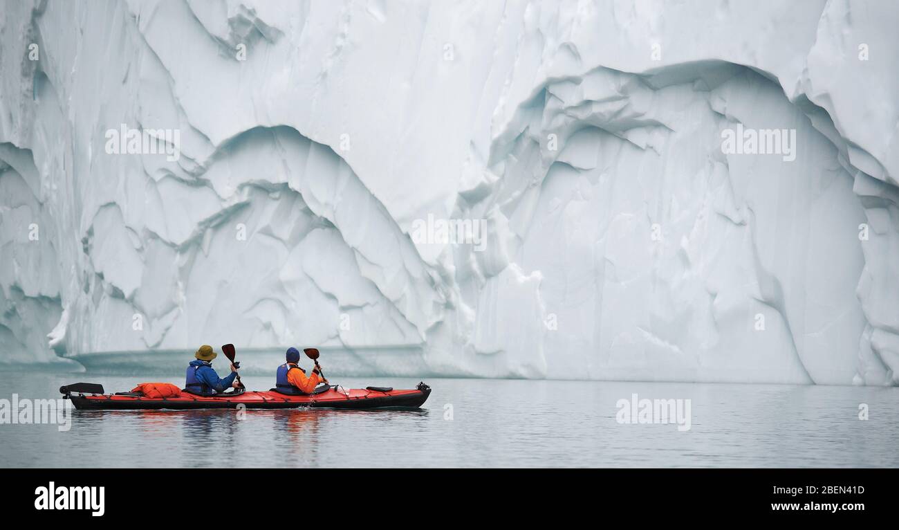 2 hombres viajando con un kayak de mar en Groenlandia Oriental Foto de stock