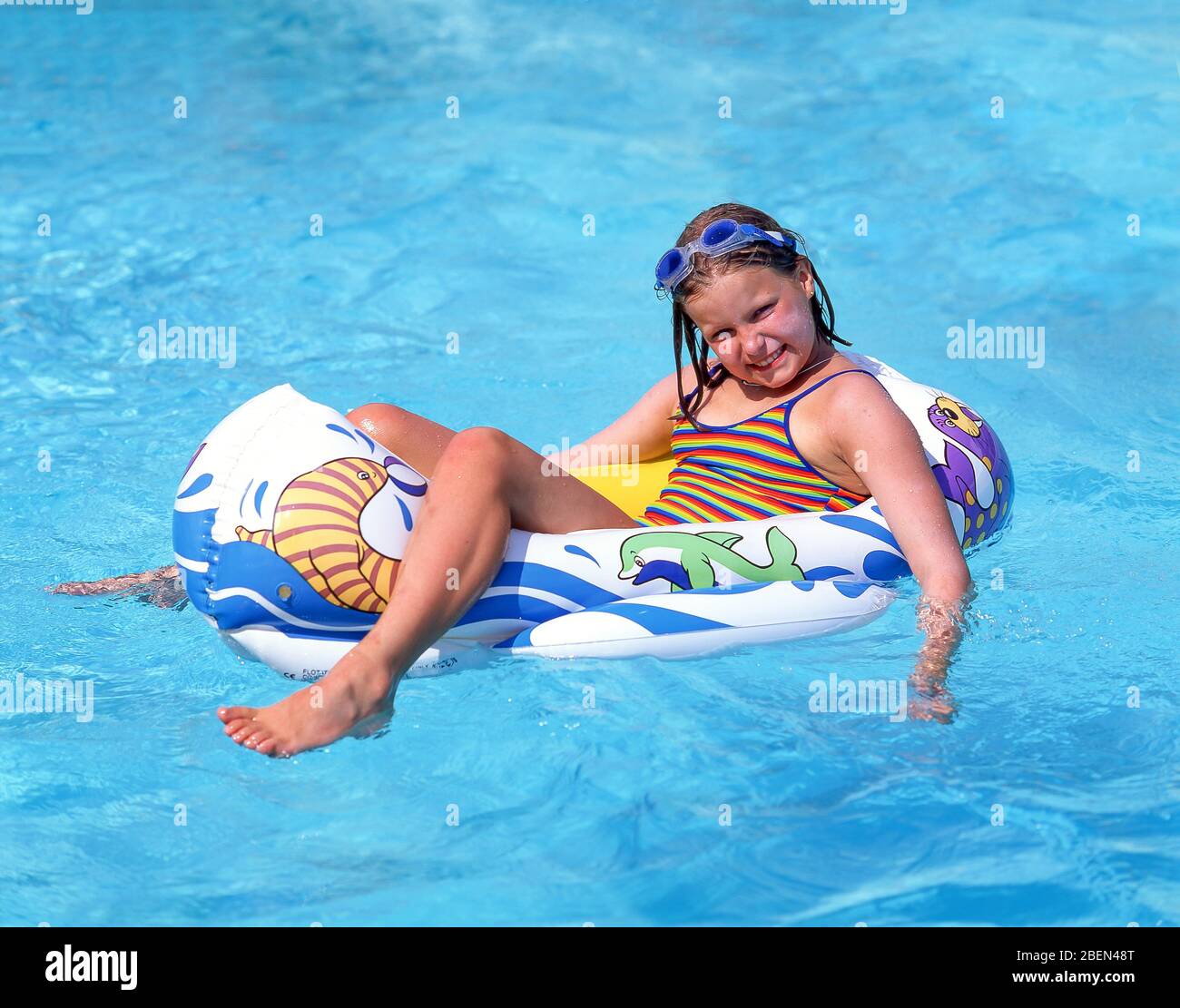 Niña en bote inflable en piscina del hotel, Arenal d'en Castell, Menorca, Islas Baleares, España Foto de stock