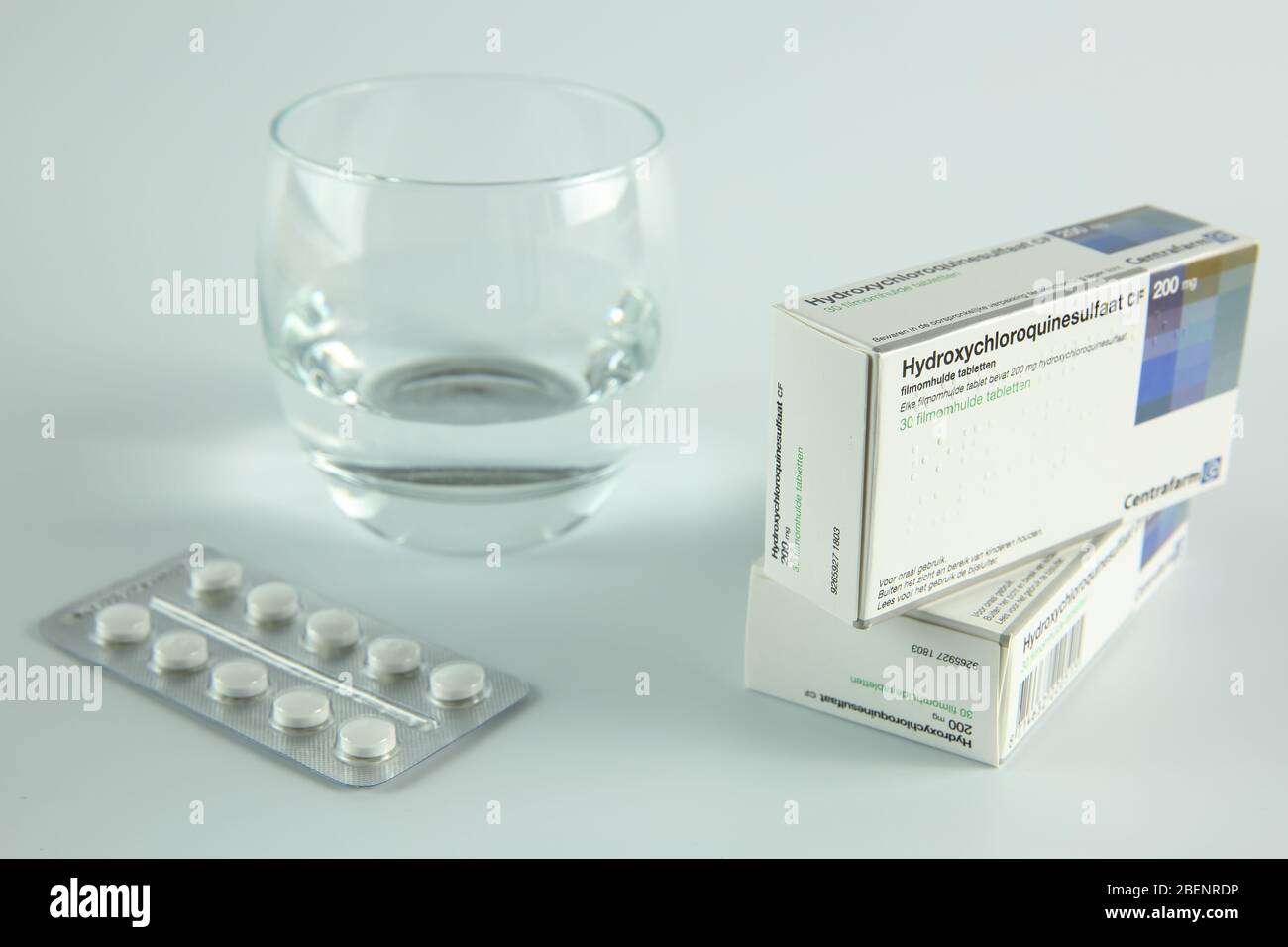 AMSTERDAM, PAÍSES BAJOS - 08 DE ABRIL de 2020: Una caja y tabletas de hidroxicloroquina, también conocida como Plaquenil, con fondo blanco Foto de stock