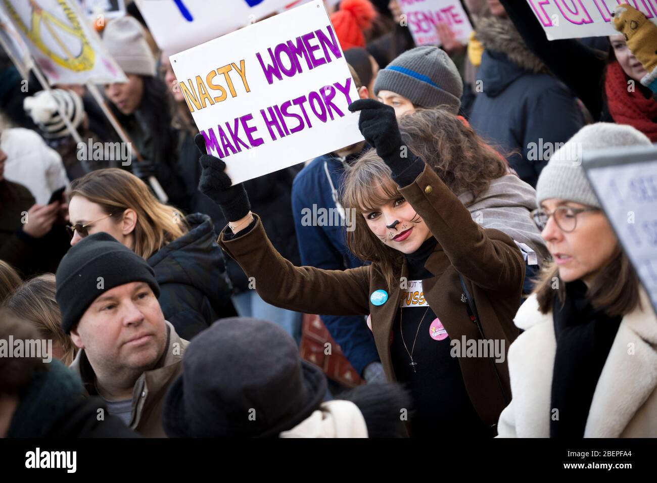 Mujer protestera con maquillaje de gato y sosteniendo un cartel que dice "Nasty Women Make History" en la marcha de las mujeres de 2017, Londres Foto de stock