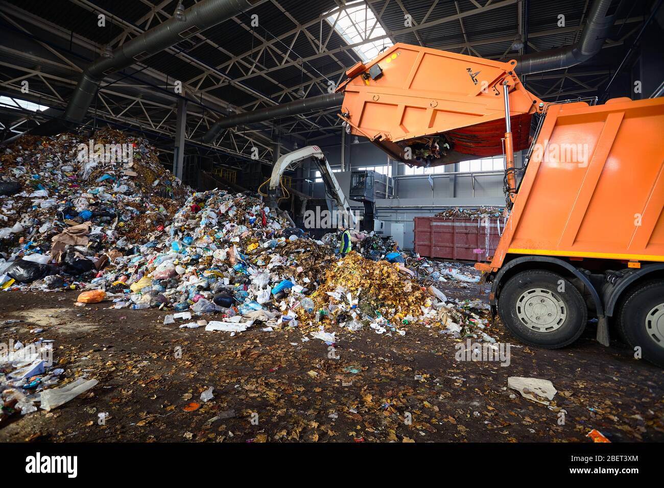 GRODNO, BIELORRUSIA - OCTUBRE 2018: Planta de reciclaje de residuos proceso de carga de basura de camiones de basura. El manipulador carga basura en el transportador para más Foto de stock