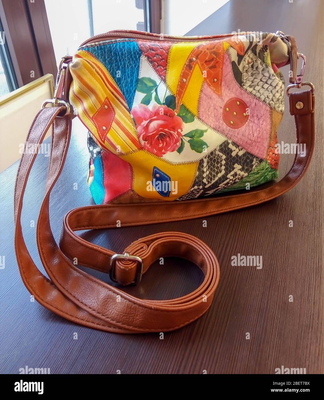Primer plano de una pequeña cartera beige vintage sobre un fondo de mesa  marrón. Marrón vintage pequeño bolso de mujer con correa Fotografía de  stock - Alamy