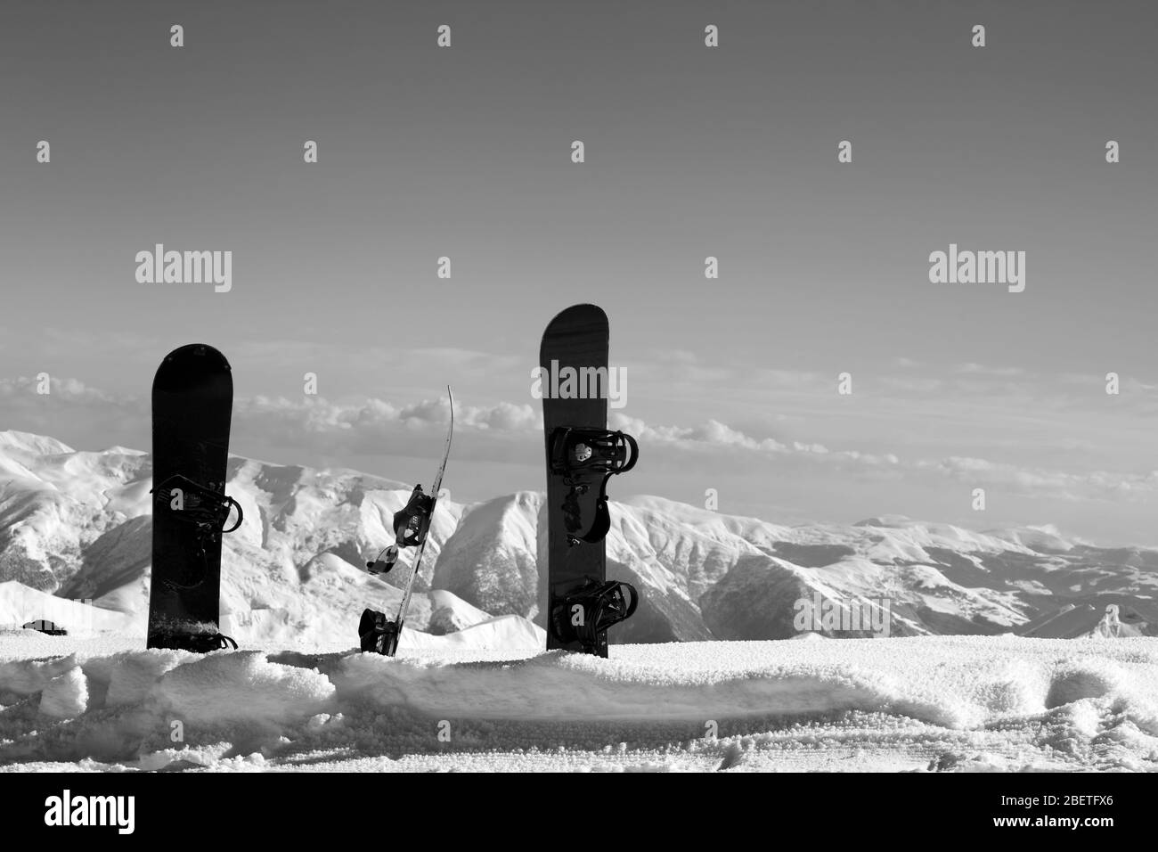 Tres snowboards en deriva cerca de pistas nevadas fuera de pista en el sol día de invierno. Montañas del Cáucaso, Georgia, región Gudauri. Landsca de tonos blanco y negro Foto de stock