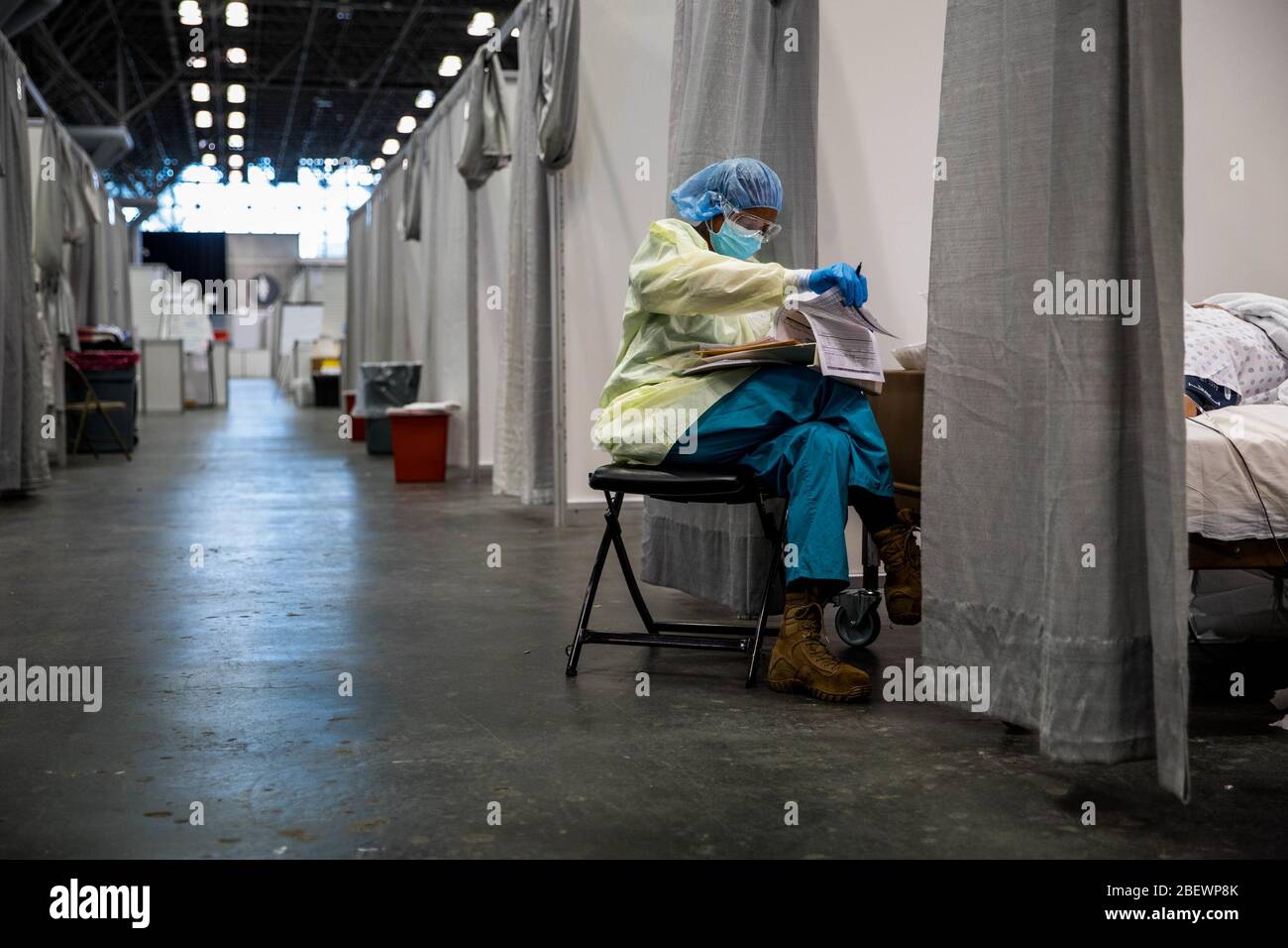 Manhattan, Estados Unidos de América. 14 de abril de 2020. NUEVA YORK (14 de abril de 2020) UN proveedor médico asignado a la Estación médica Javits de Nueva York monitorea a un paciente con COVID-19 en estado crítico en la unidad de cuidados intensivos de facilityÕs, 11 de abril de 2020. El comando Norte de los Estados Unidos, a través del Ejército Norte de los Estados Unidos, está proporcionando apoyo militar a la Agencia Federal de Administración de Emergencias para ayudar a las comunidades necesitadas. Crédito: Storms Media Group/Alamy Live News Foto de stock