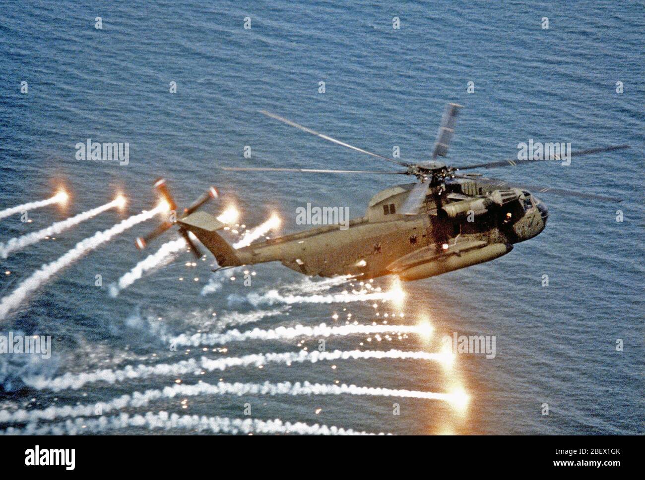 Un aire-aire Vista lateral derecha de un semental de tipo CH-53D Mar helicóptero arrojando bengalas, cerca de la Estación Aérea Naval de Patuxent River, Maryland, el helicóptero se va a través de una evaluación de la UN/ALC-39 contramedidas sistema dispensador, utilizado para proporcionar protección contra las armas guiadas. Foto de stock