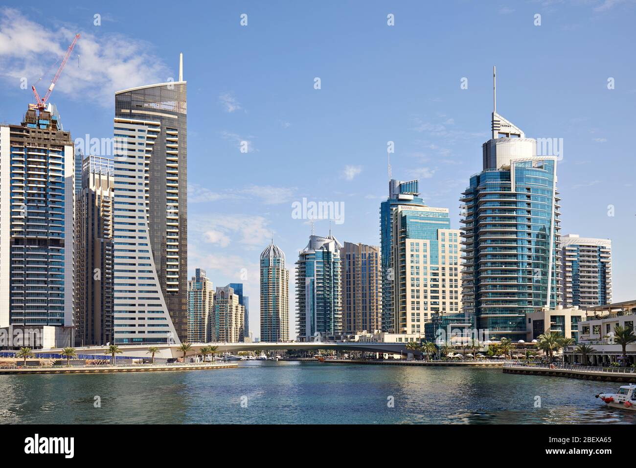 DUBAI, EMIRATOS ÁRABES UNIDOS - 23 DE NOVIEMBRE de 2019: Dubai Marina Canal con puente y rascacielos en un día soleado, cielo azul en Dubai Foto de stock