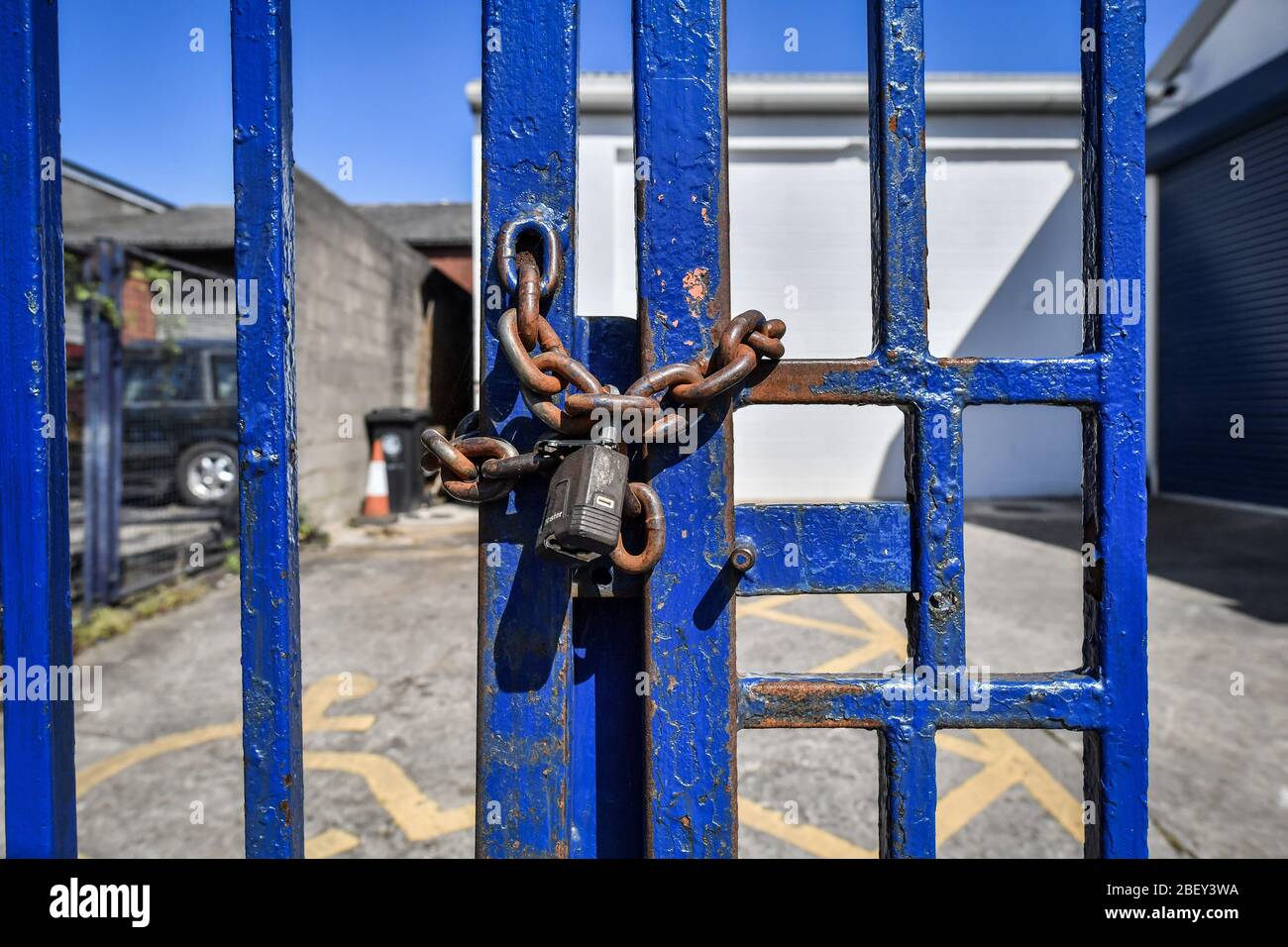 NOTA: IMAGEN 8 DE UN CONJUNTO DE 35 IMÁGENES CON PUERTAS CERRADAS DE NEGOCIOS Y LUGARES QUE ESTÁN CERRADOS DURANTE EL CIERRE del Reino Unido UNA cadena oxidada y candado asegurar puertas de acero pintado de color azul para impedir el acceso a un negocio en una propiedad comercial en Bristol como el Reino Unido sigue en cierre ayudar a frenar la propagación del coronavirus. Foto de stock