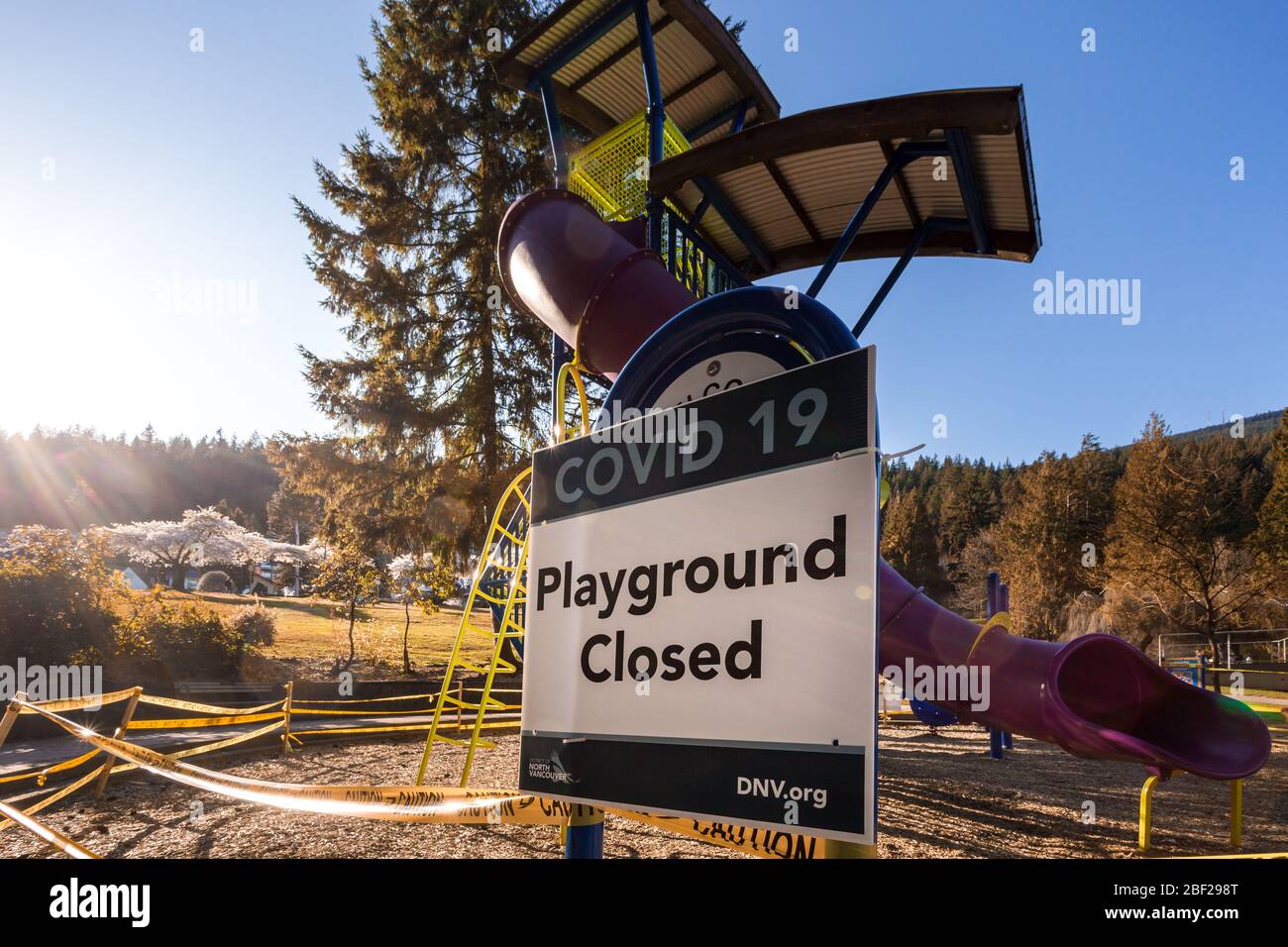 NORTH VANCOUVER, BC, CANADÁ - 11 DE ABRIL de 2020: Un parque infantil cerrado en un parque público North Vancouver con cinta de precaución para ayudar a frenar el Foto de stock