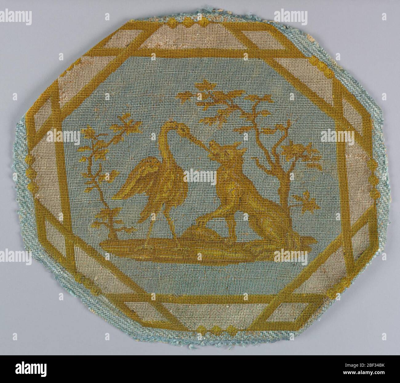 Asiento de silla. Medallón octogonal de tela de tapicería que ilustra una  fábula de Aesop conocida como 'el zorro y el cuervo'. El patrón es de color  blanco y tonos de amarillo