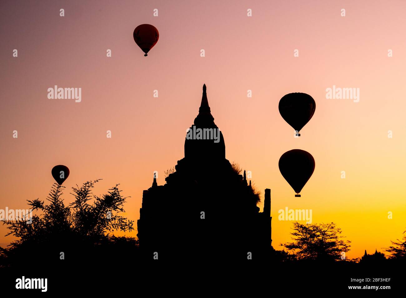Globos de aire caliente al amanecer detrás y pagoda sin nombre en Bagan, Myanmar Foto de stock