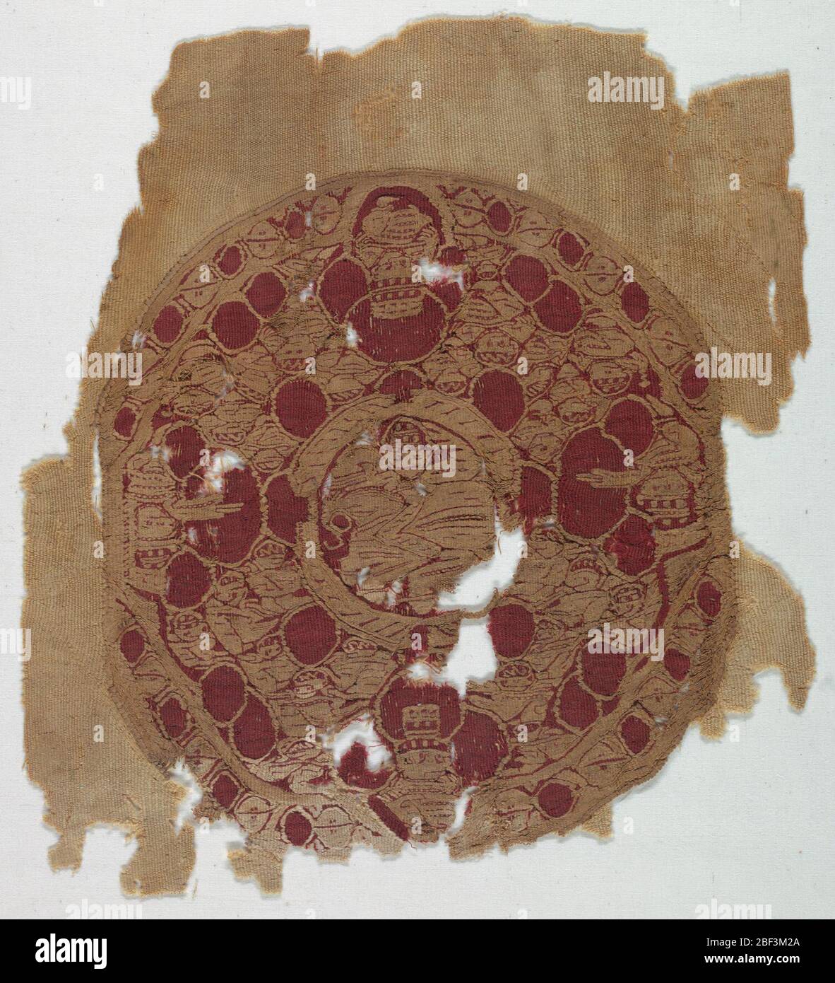 Textil. Medallón circular tejido con tapices en marfil y lana roja en las cetas de un tejido de lana de marfil de tejido liso con cara de trama. Foto de stock