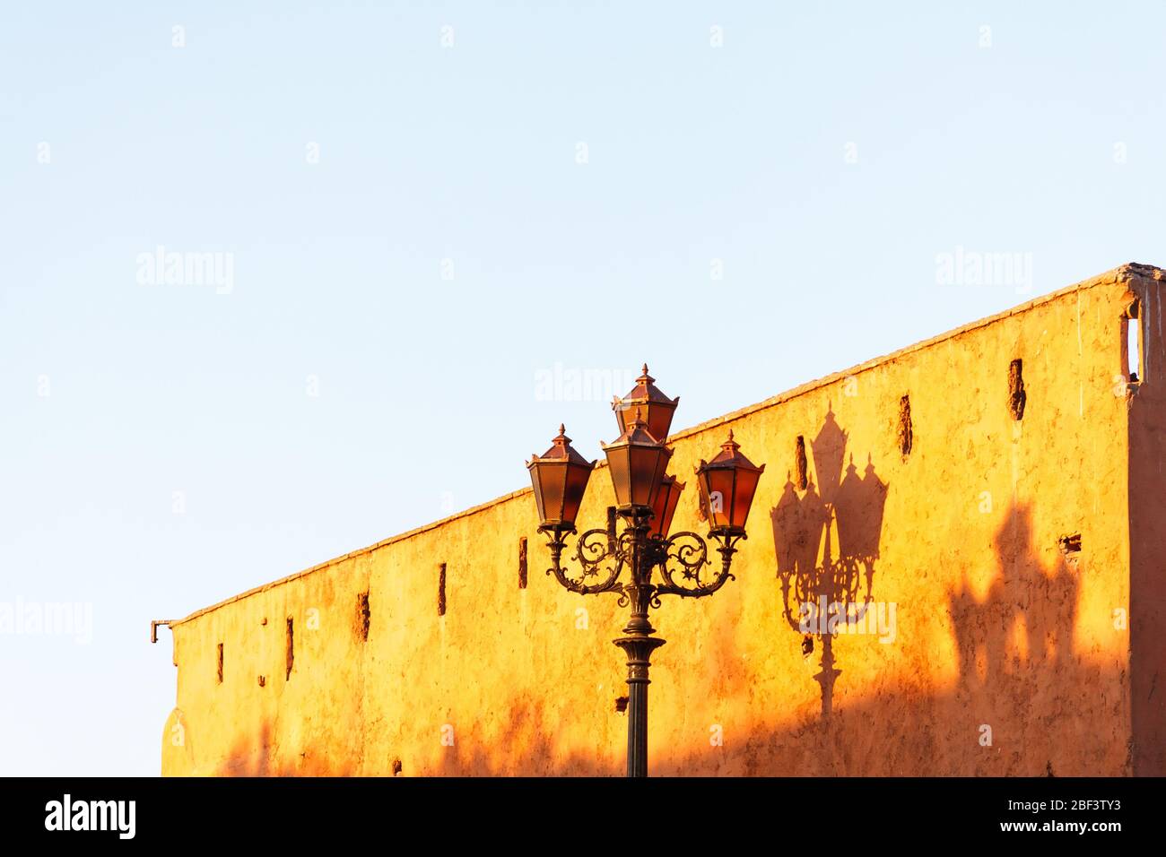 Poste ornamentado que refleja la sombra en una pared en Marrakech, Marruecos Foto de stock