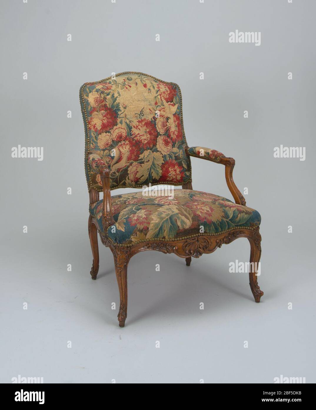 Sillón. Este conjunto de sillas (2) consiste en dos antiguos sillones  cubiertos con tapices Aubusson del período Luis XV. Los sillones tienen  respaldo y asientos curvos tapizados en tejido floral de color
