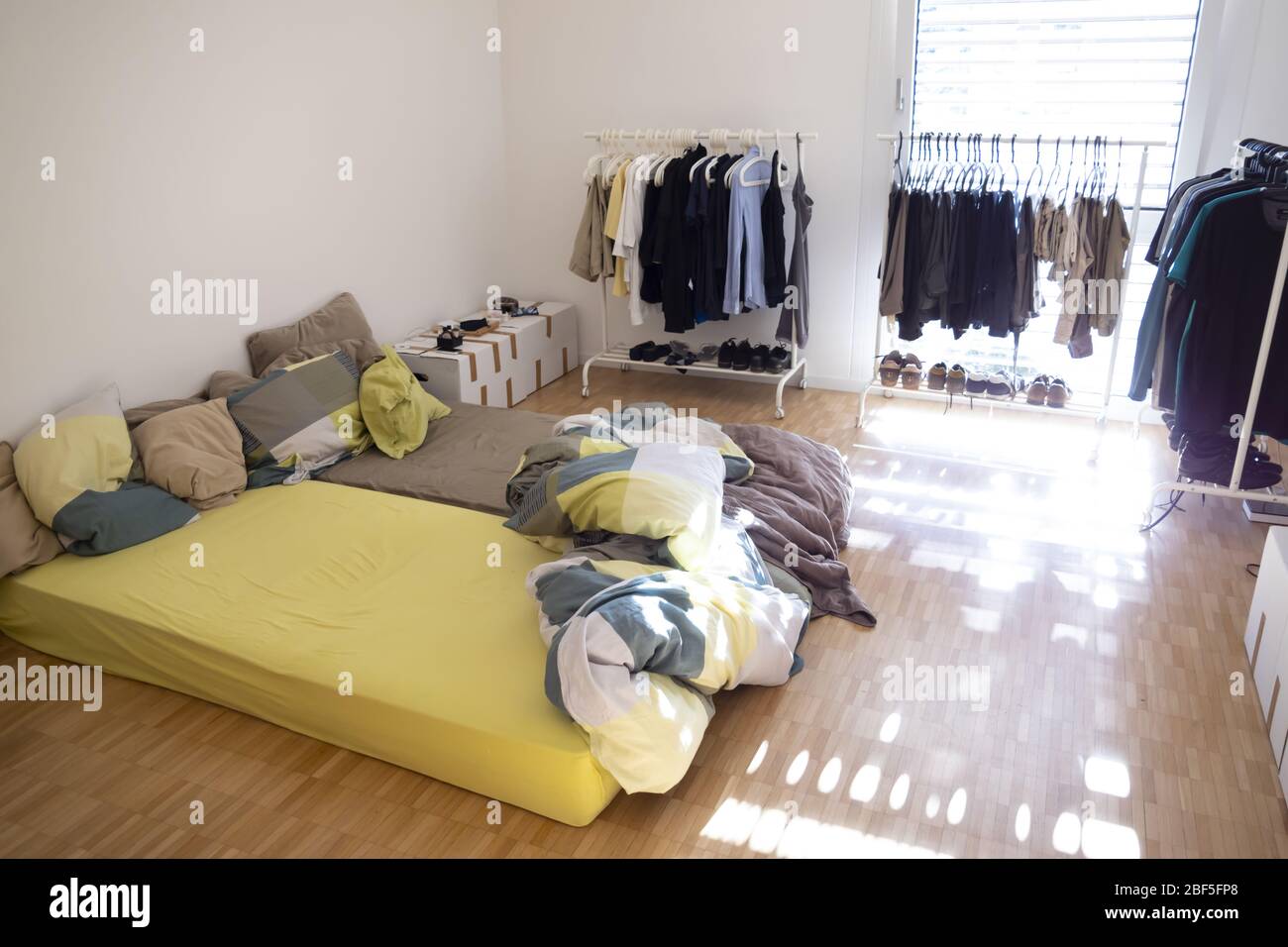 Habitación de cama, los colchones en el suelo, perchero de cremallera y  zapatos Fotografía de stock - Alamy