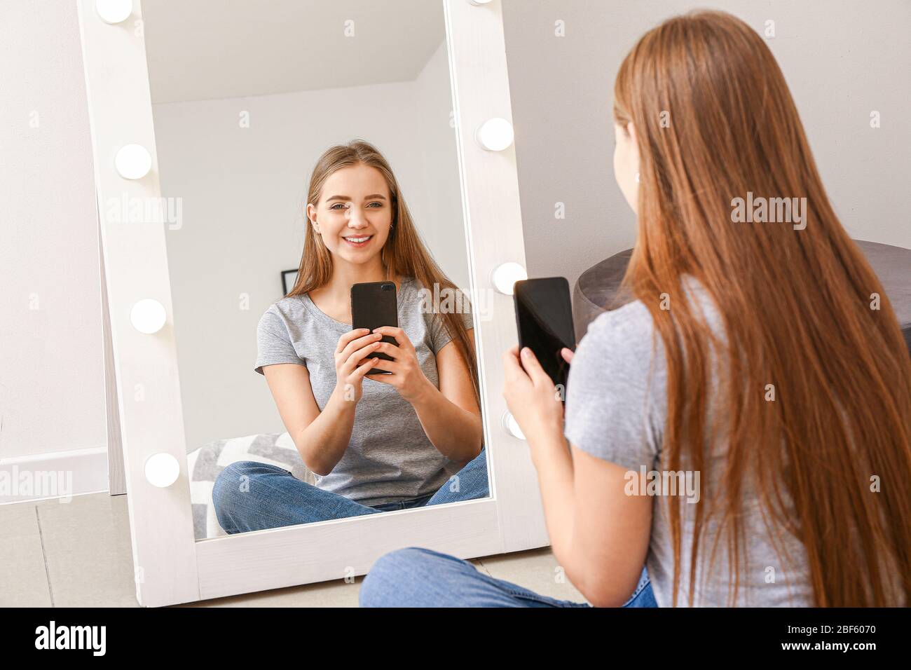Hermosa mujer joven tomando selfie delante del espejo en casa Fotografía de  stock - Alamy