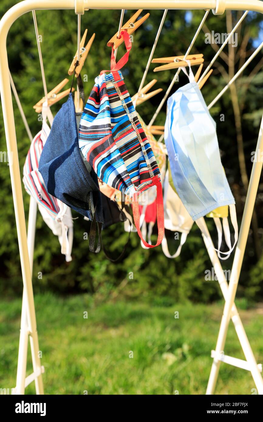 Mascarilla higiénica colgando en el rack al aire libre después de lavarse  para limpieza e higiene durante el brote del virus Covid-19 . Máscara de  Anti virus hecha a mano a p