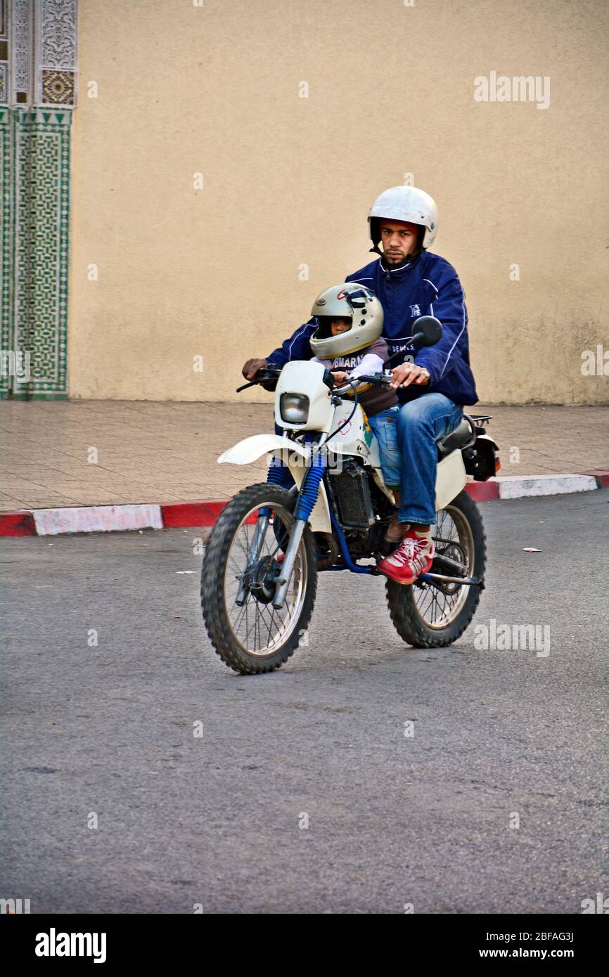 Fes, Marruecos - 20 de noviembre de 2014: Conductor no identificado con niño en bicicleta, modo habitual de transporte Foto de stock
