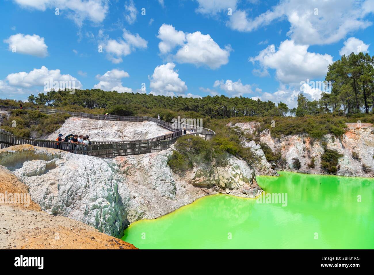 Visitantes por la piscina de azufre Devil's Bath en Wai-o-Tpu Thermal Wonderland, cerca de Rotorua, Nueva Zelanda Foto de stock