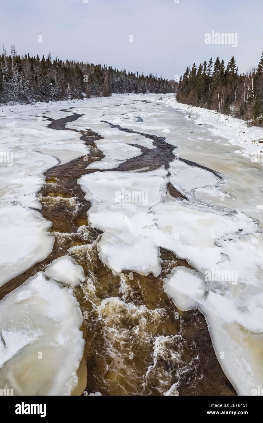 Buchans River tallado a través de nieve y hielo en Buchans, Terranova, Canadá Foto de stock