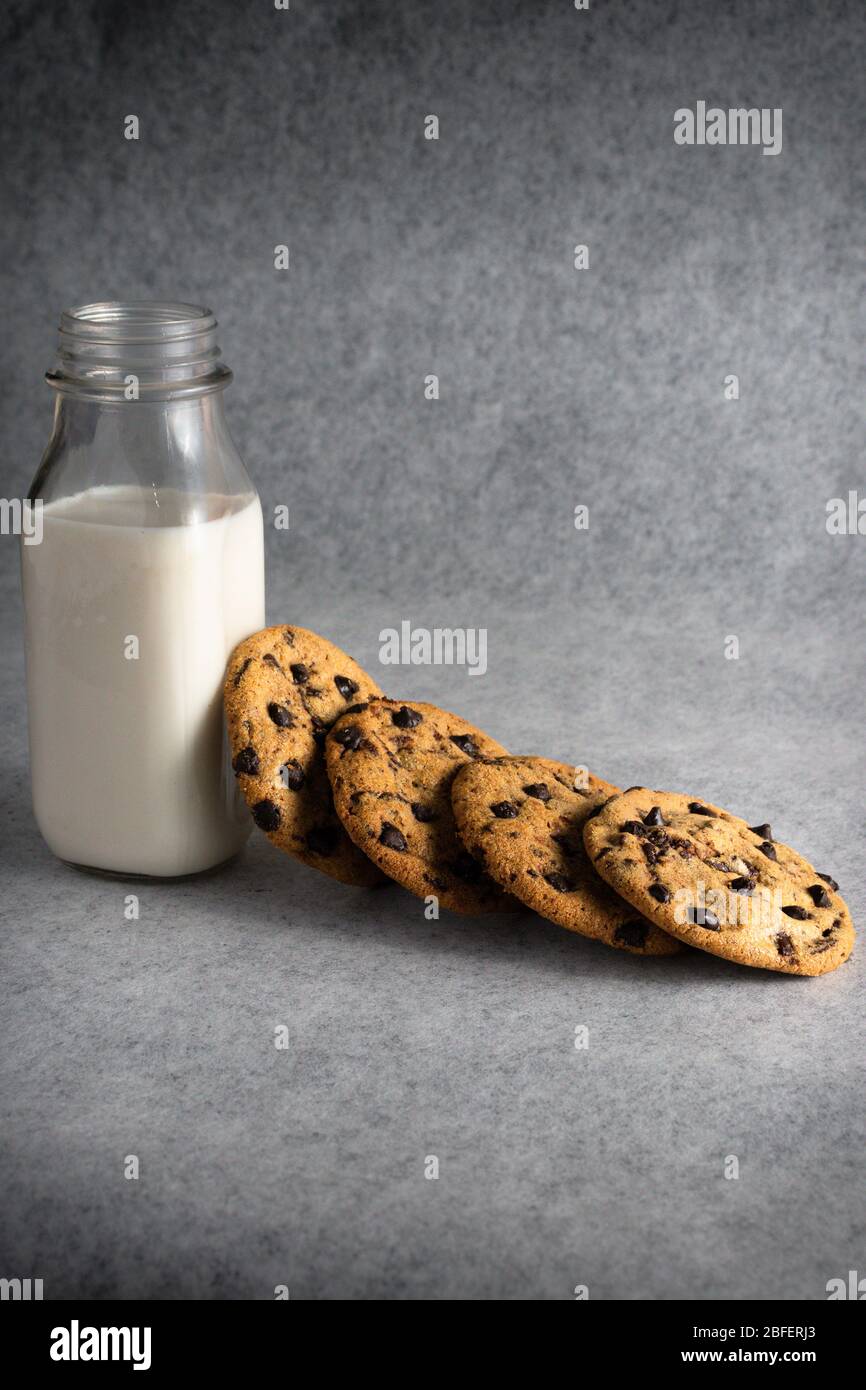pila de galletas con trocitos de chocolate con una botella de leche Foto de stock
