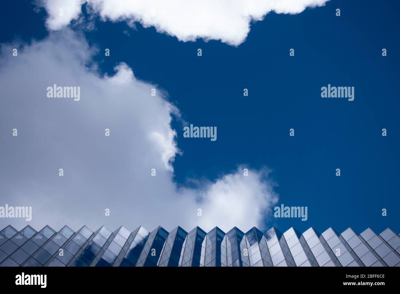 Reflexiones y ángulos de arquitectura abstractos fijados sobre un cielo azul enmarcado para la geometría Foto de stock