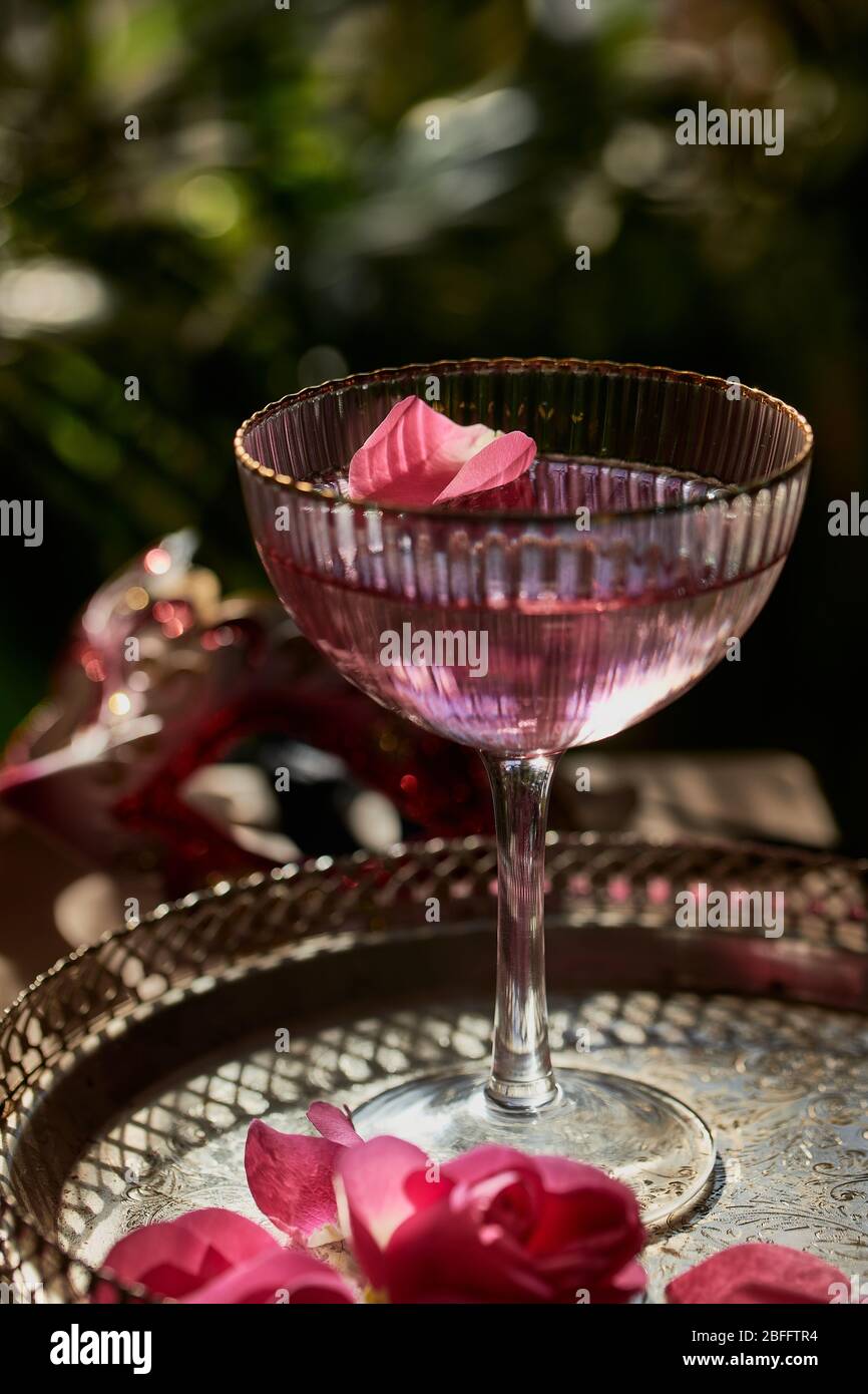 Cóctel de champán rosa en copa con pétalos de rosa Fotografía stock - Alamy