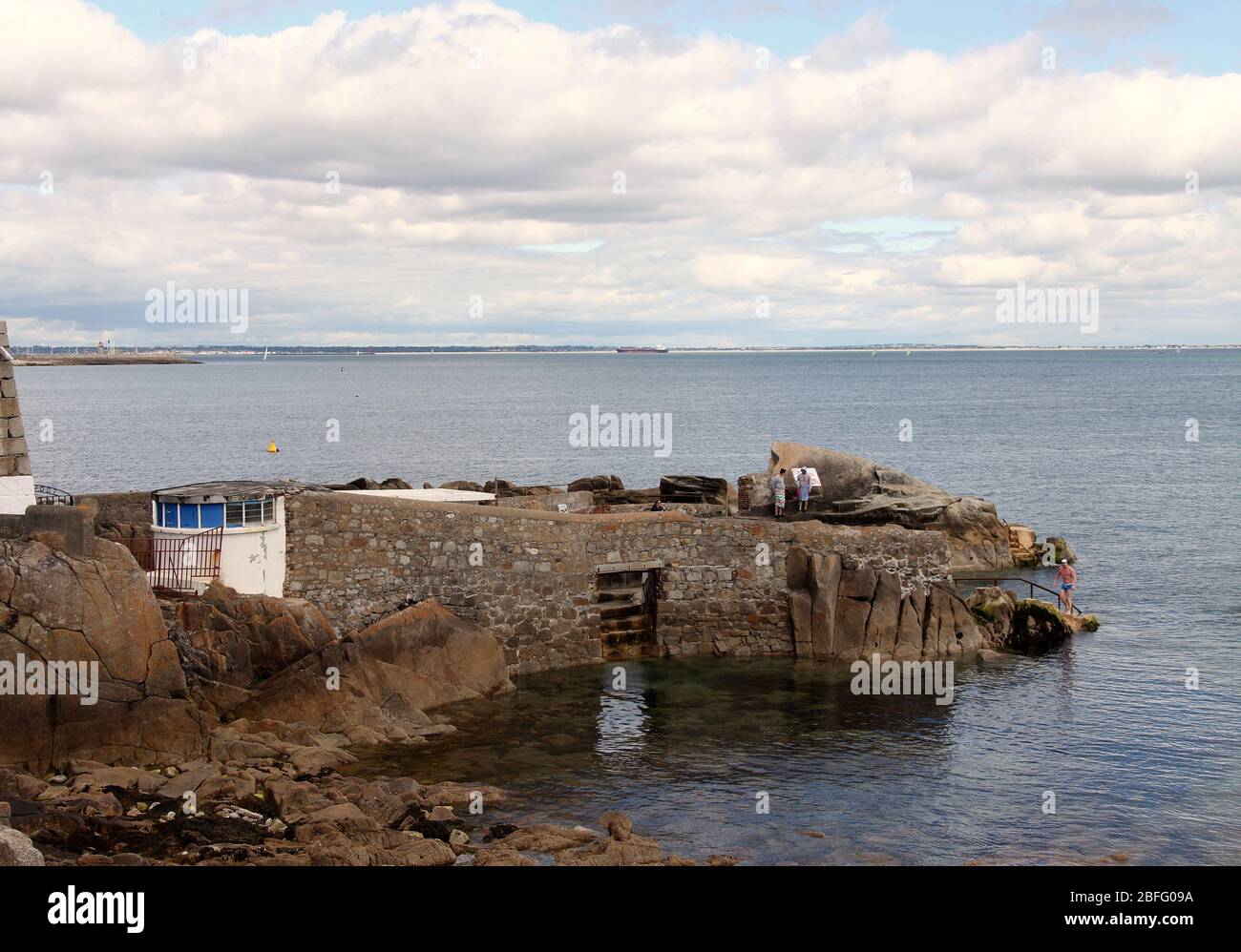 Nadadores en el mar irlandés a los históricos cuarenta pies en Sandycove Foto de stock