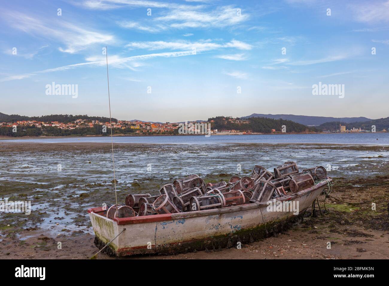Pequeño barco abandonado lleno de herramientas de pesca en una playa de  Combarro en Galicia, España Fotografía de stock - Alamy