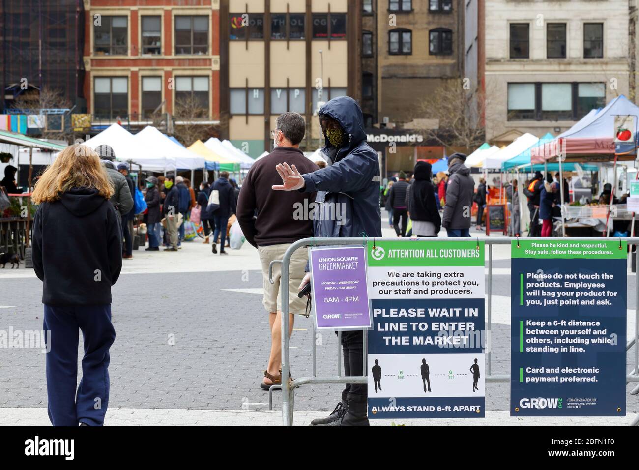 Una persona encargada de prevenir el hacinamiento en el mercado verde de Union Square durante la crisis del coronavirus COVID-19. Nueva York, 18 de abril de 2020. No entre Foto de stock