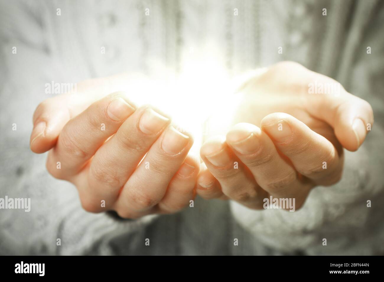 Luz en las manos. Concepto de toma, cuidado, protección Fotografía de stock  - Alamy