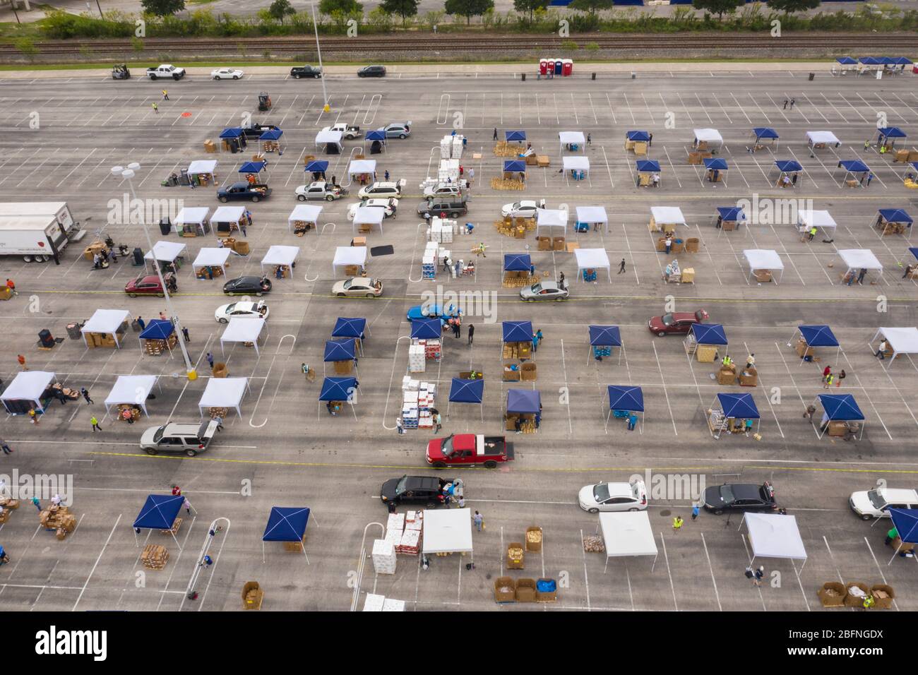 Vista aérea de cientos de autos alineados para recibir ayuda alimentaria del USDA Food and Nutrition Service y del San Antonio Food Bank a familias que sufren los efectos de la pandemia de coronavirus COVID-19 en el Alamodome el 17 de abril de 2020 en San Antonio, Texas. Foto de stock