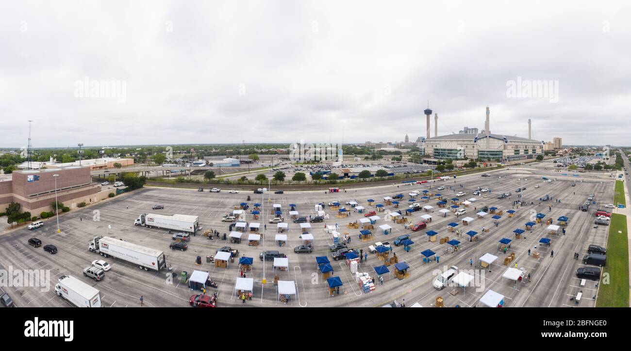 Vista aérea de cientos de autos alineados para recibir ayuda alimentaria del USDA Food and Nutrition Service y del San Antonio Food Bank a familias que sufren los efectos de la pandemia de coronavirus COVID-19 en el Alamodome el 17 de abril de 2020 en San Antonio, Texas. Foto de stock