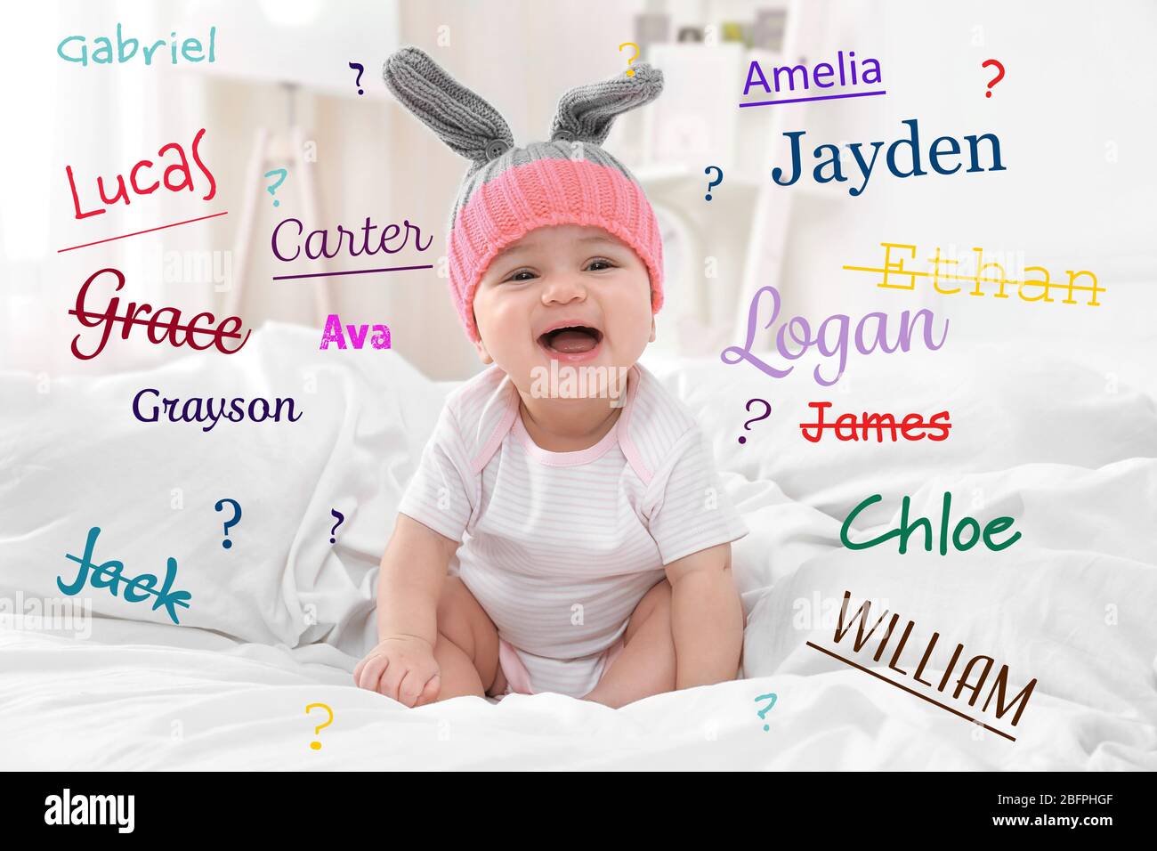 Concepto de nombres de bebés. Un niño pequeño y lindo sentado en la cama Foto de stock