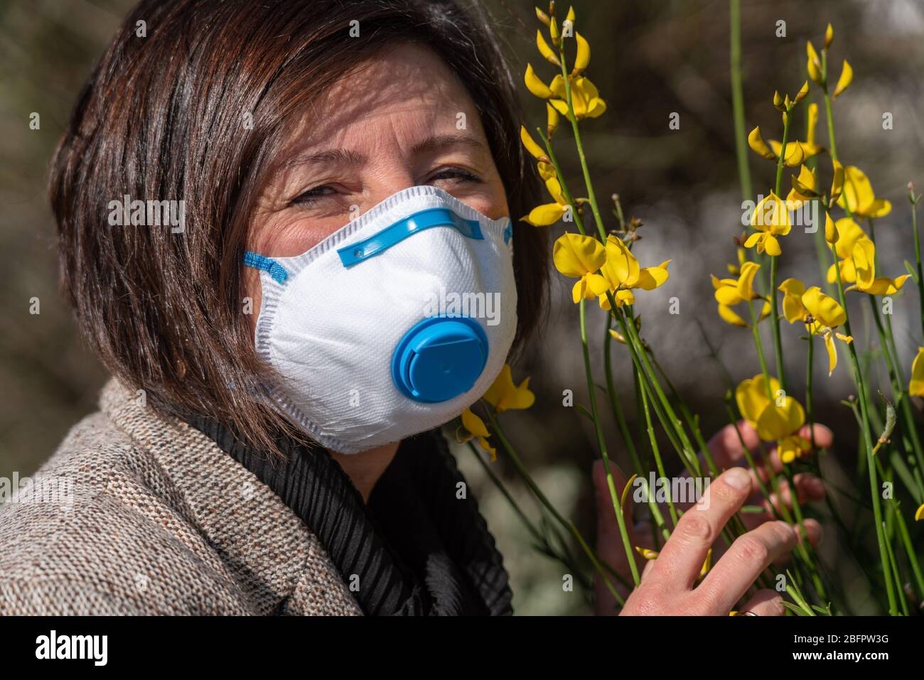Una mujer en una máscara en su cara, para proteger contra las alergias de  primavera y contra el coronavirus Fotografía de stock - Alamy