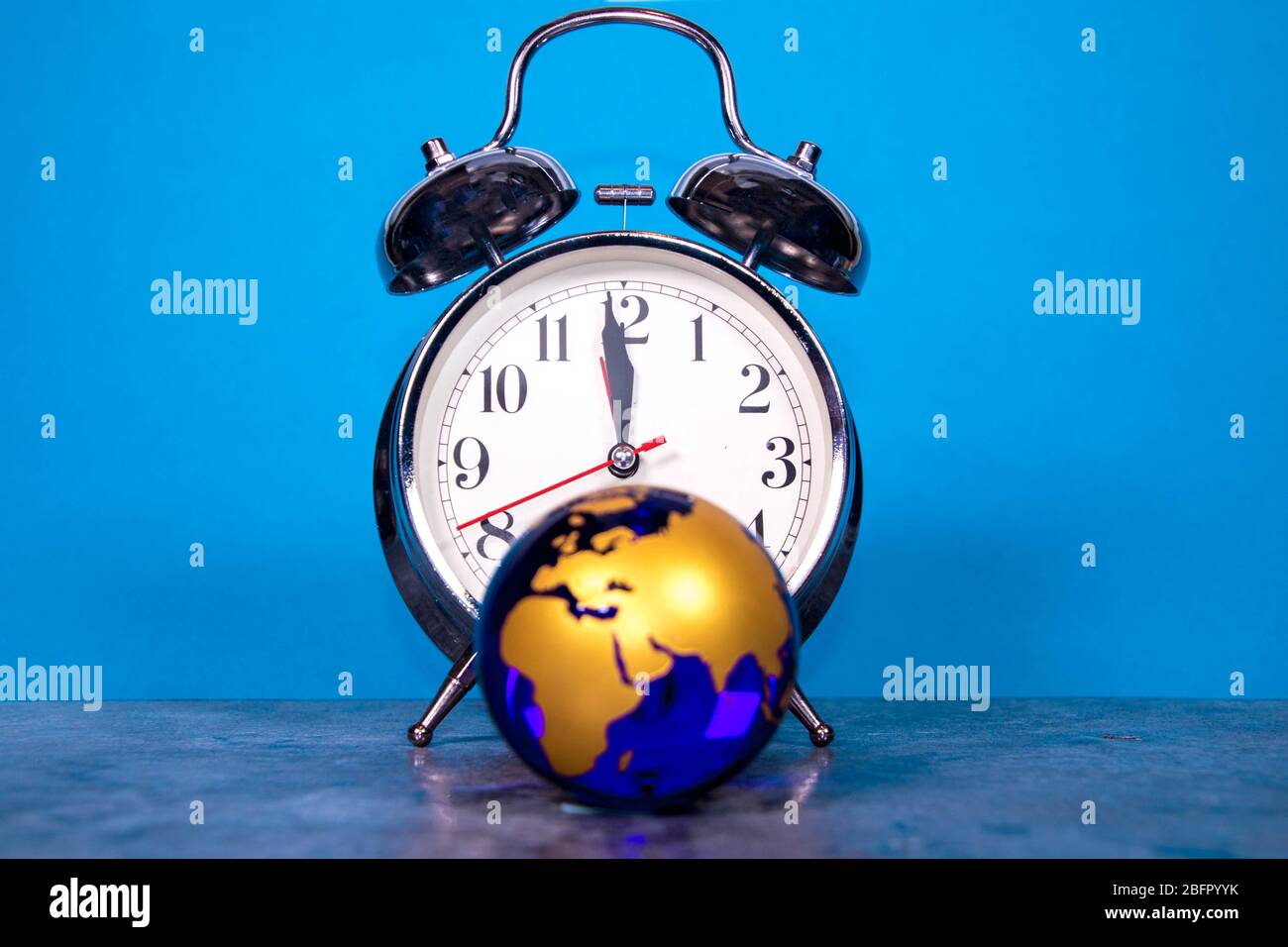 Un reloj analógico grande cuenta hacia abajo a un acontecimiento global o representa la hora que se está acabando. Foto de stock