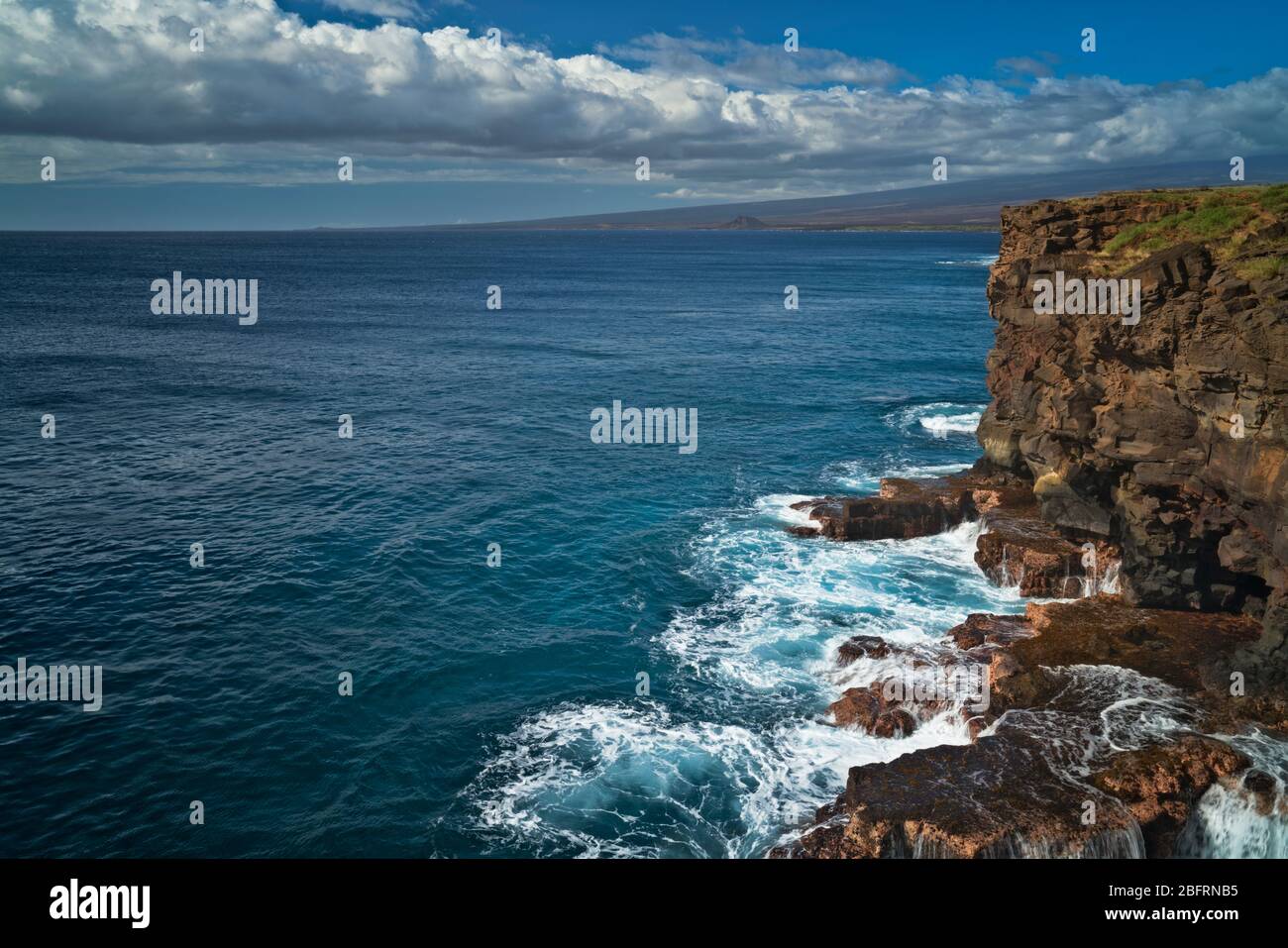 Las olas chocan contra los acantilados volcánicos en South Point en la Gran Isla de Hawai y la ubicación más meridional en los Estados Unidos. Foto de stock